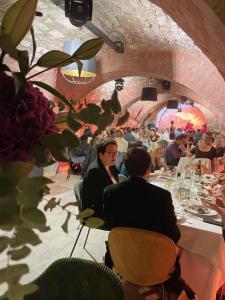 un groupe de personnes assises à des tables dans un restaurant dans l'établissement Le M. Musée du vin - l'appartement, à Paris