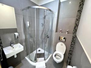 La salle de bains est pourvue d'une douche, de toilettes et d'un lavabo. dans l'établissement Symfonia, à Piotrków Trybunalski