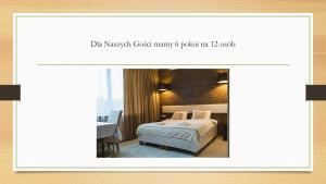 une chambre d'hôtel avec un lit et une table dans l'établissement Symfonia, à Piotrków Trybunalski