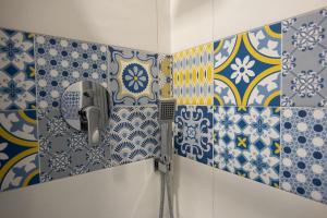 a shower in a bathroom with blue and white tiles at Seaview in Salerno