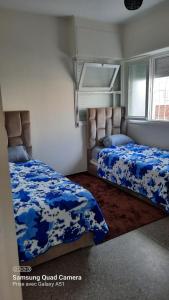 a bedroom with two beds with blue sheets and a window at villa agadir in Agadir