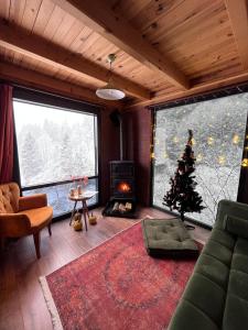 a living room with a christmas tree and a fireplace at Kukudi House in Ayder Yaylasi