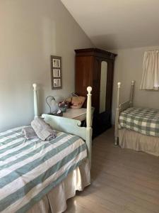 1 Schlafzimmer mit 2 Betten und einer Kommode mit einem Bett m2 in der Unterkunft French Beach House Shirley BC in Shirley