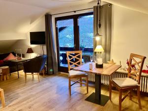 sala de estar con mesa, sillas y ventana en Ferienappartment Zürker, en Garmisch-Partenkirchen
