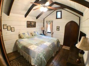 um quarto com uma cama e uma ventoinha de tecto em Tiny Home Cottage Near the Smokies #5 Fleur em Sevierville