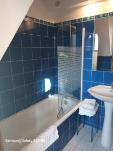 baño de azulejos azules con bañera y lavamanos en Mas Sant Salvador, en Bompas