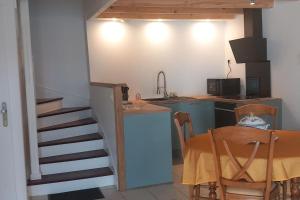 cocina con mesa y cocina con escalera en Maison de campagne au calme, en Molac