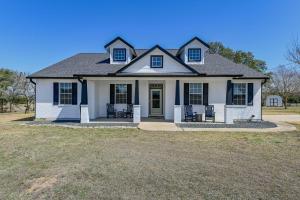 uma casa branca com janelas pretas num quintal em Oak Hollow em Liberty Hill