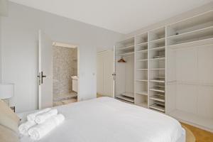 Habitación blanca con cama y estanterías blancas en De Meir & Opera Urban Elegance Apt, en Amberes