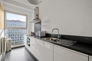 a kitchen with a sink and a large window at De Meir & Opera Urban Elegance Apt in Antwerp