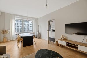 un soggiorno con grande TV e tavolo di De Meir & Opera Urban Elegance Apt ad Anversa