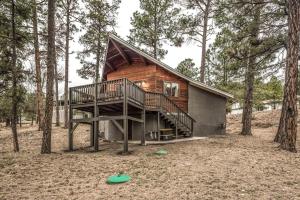 a log cabin in the woods with a staircase at Peak In The Pines in Ruidoso