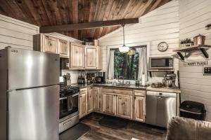 a kitchen with wooden cabinets and a stainless steel refrigerator at Peak In The Pines in Ruidoso +20 photos