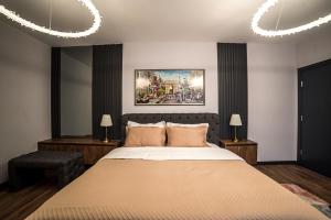 um quarto com uma cama grande e 2 candeeiros em ARHEYA 4 apart / АРХЕЯ 4 апартамент за гости em Karlovo
