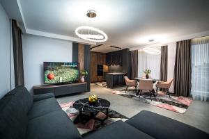 uma sala de estar com um sofá e uma mesa em ARHEYA 4 apart / АРХЕЯ 4 апартамент за гости em Karlovo