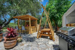 einen Hinterhof mit einem Pavillon, einem Tisch und einem Grill in der Unterkunft Road Runner Lodge in Austin