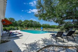 einen Pool mit vier Stühlen und einem Baum in der Unterkunft Road Runner Lodge in Austin