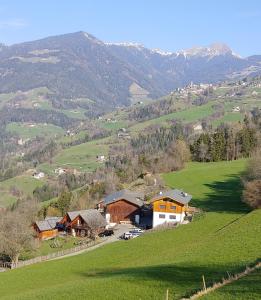 a house on a hill in a green field at Unterplattnerhof in Chiusa