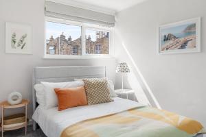 a bedroom with a bed and two windows at Stylish 3 Bed with Outdoor space in Vibrant East London in London