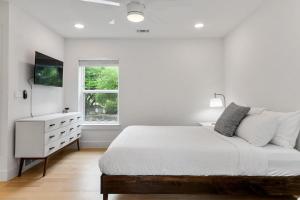 1 dormitorio blanco con 1 cama, vestidor y ventana en East Side Marvel, en Austin