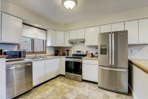 a kitchen with white cabinets and stainless steel appliances at Destination Dells Vacation Home at Tamarack Resort in Wisconsin Dells