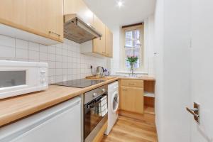 een keuken met een magnetron en een vaatwasser bij Regent's Park apartment in Londen