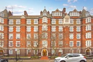 a white car parked in front of a large brick building at Regent's Park apartment in London