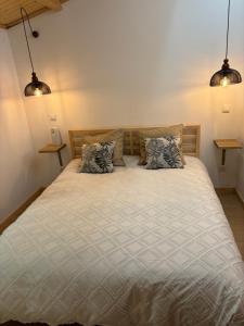 a bedroom with a bed with two pillows at Caparica wood house in Caparica