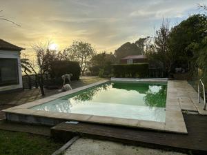 a dog is sitting next to a swimming pool at Caparica wood house in Caparica