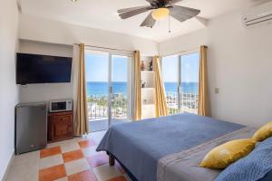 sypialnia z łóżkiem i telewizorem oraz balkon w obiekcie MariaMar Suites w mieście San José del Cabo