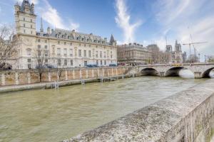eine Brücke über einen Fluss in einer Stadt mit Gebäuden in der Unterkunft Git le cœur in Paris