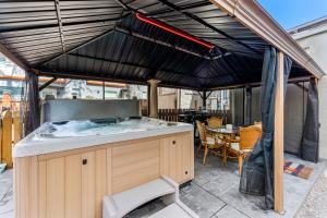 an outdoor kitchen with a hot tub on a patio at HOT TUB Firepit Pool Table Patio Cozy Downtown Denver in Denver