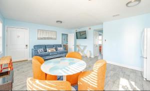 een woonkamer met een tafel en stoelen en een bank bij Steps to Sand Updated Bouchee Beachy Condo Deck Parking in Brigantine