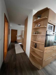 a room with a kitchen with wooden shelves at Krásny apartmám CENTRUM in Martin