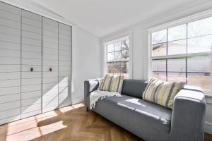 a living room with a couch and two windows at Canterbury Cottage in Austin