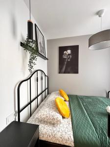 カトヴィツェにあるKościuszki Cozy Apartments Centrumのベッドルーム1室(黄色い枕のベッド1台付)