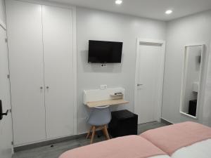 a bedroom with a bed and a tv on the wall at Matallana 32 in Herencia