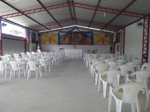 a row of white chairs in a large room at Comunidade Anuncia-Me in Guaratinguetá
