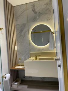 a bathroom with a sink and a mirror at Apart moderno 3 suites 2 vagas de garagem e quadra do mar in Itapema