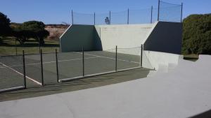 una pista de tenis con red en una pista de tenis en Las Brusquitas Apart en Miramar