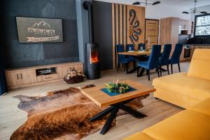 sala de estar con mesa y chimenea en Chalety v Pieninách, en Červený Kláštor