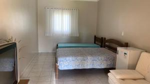 - une petite chambre avec un lit et un canapé dans l'établissement Aguas de São Pedro lugar Familiar e Aconchegante, à São Pedro