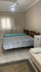 a bedroom with a bed and a couch at Aguas de São Pedro lugar Familiar e Aconchegante in São Pedro