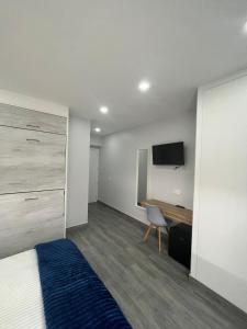 a bedroom with a bed and a desk and a tv at Matallana 32 in Herencia +37 photos
