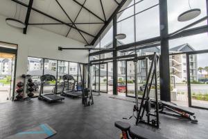 a gym with cardio equipment and large windows at Bella Cabana Luxury Apartment in Summerstrand