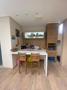 uma cozinha com mesa e cadeiras num quarto em Guaibim House- Sua casa de praia em Guaibim