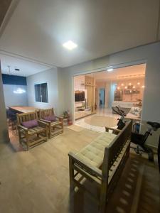 sala de estar con bancos, mesa y cocina en Guaibim House- Sua casa de praia en Guaibim