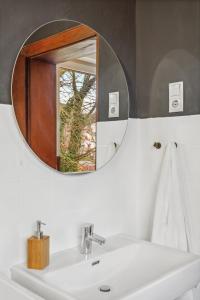 een badkamer met een witte wastafel en een spiegel bij DD_Homes - Große 4 Raum Wohnung Andernach am Rhein mit Terrasse in Andernach