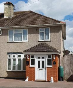 a house with two cats sitting in front of it at Delight Marvel-Derby House at Maidstone in Maidstone