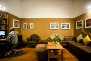 a man sitting in a living room watching a television at Hostal Solar in Arequipa